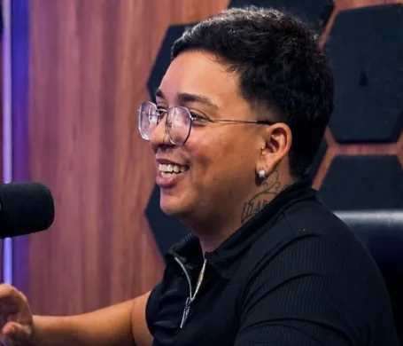 Professor Tonhão sorrindo durante uma conversa ao microfone
